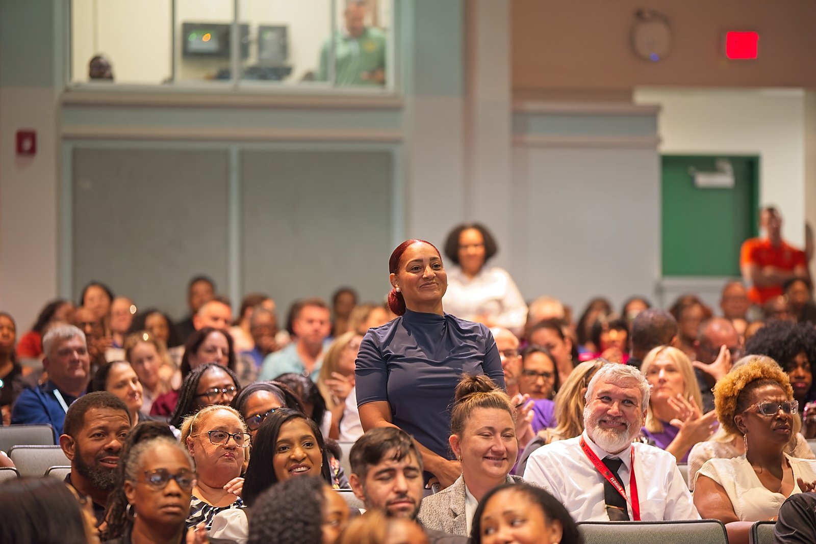 An administrator recognized, standing among colleagues during a general session