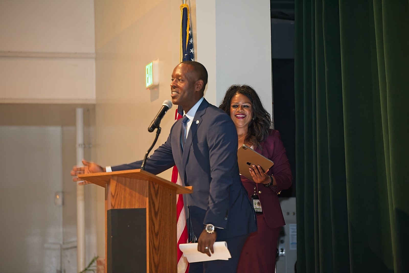 Two presenters sharing the stage at the podium