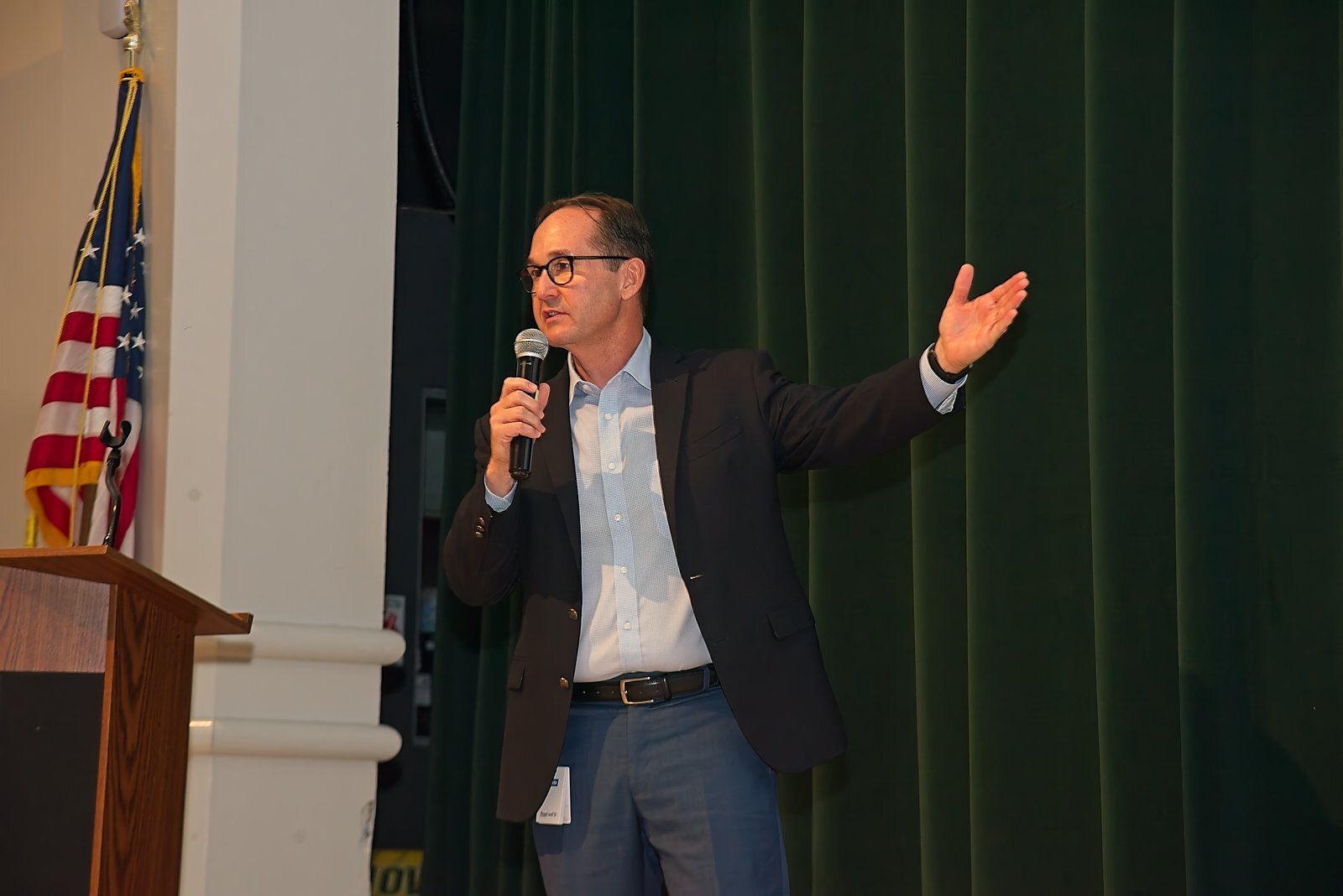 A presenter gesturing while speaking at the podium